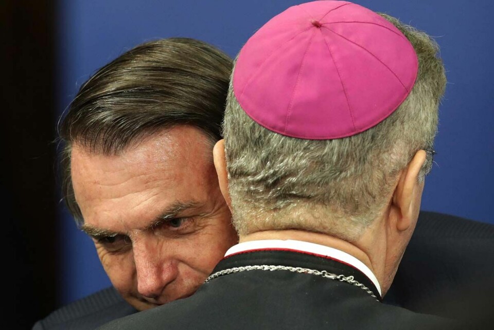 Brasiliens president Jair Bolsonaro omfamnar biskop Fernando Areas Rifan. Arkivbild.
