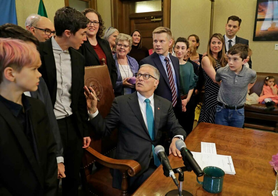 Washington-guvenören Jay Inslee undertecknar lagen som gör Recompose-metoden tillåten. Till vänster, Katrina Spade.